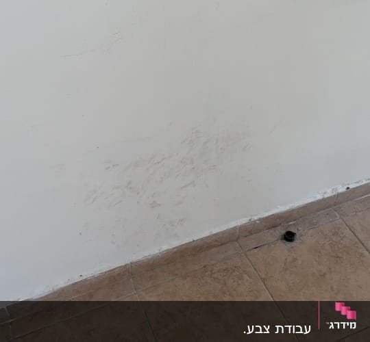 קיר עם סימני לכלוך ורצפת אריחים